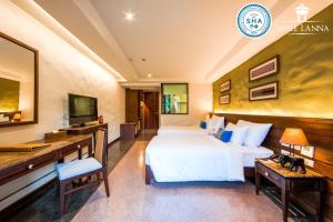a hotel room with two beds and a desk at Smile Lanna Hotel in Chiang Mai