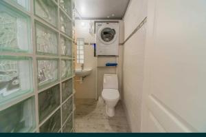 uma pequena casa de banho com WC e máquina de lavar roupa em Смарт квартира в центре Одессы em Odessa