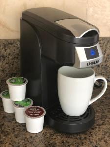 a coffee maker with a cup on a counter at Tropical Studios at Marine Surf Waikiki - FREE PARKING - BEST LOCATION - FULL KITCHEN - SWIMMING POOL in Honolulu