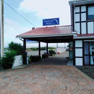 a gas station with a sign on top of it at Albatross Motel in Napier