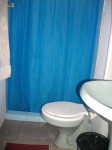 La salle de bains bleue est pourvue de toilettes et d'un lavabo. dans l'établissement Hotel Hangar, à Bagé