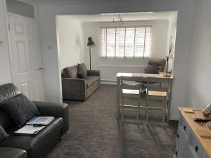 a living room with a couch and a table at Riverside Park Ground Floor Apartment - St Neots in Saint Neots