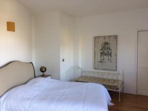 biała sypialnia z łóżkiem i kanapą w obiekcie CoTTAGE LA VILLA BOLERO w mieście Saint-Cyr-sur-Loire