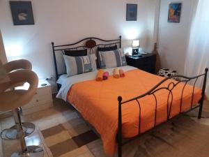 a bedroom with a bed with orange sheets and shoes on it at Nice apartments in the center of Athens! in Athens