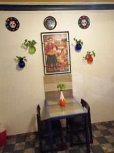 a dining room with a table and a painting on the wall at La Frida Kahlo Verde 1er piso in Mexico City