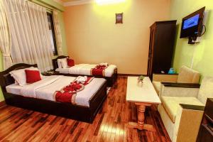 una camera d'albergo con due letti e un divano di Nepalaya Hotel a Kathmandu