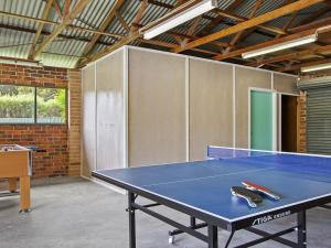 a ping pong table in a room with a tennis court at Amersham in Callala Bay +15 photos