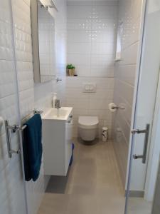 La salle de bains blanche est pourvue de toilettes et d'un lavabo. dans l'établissement Apartments CroatiaSun, à Vodice