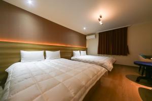 Un dormitorio con una gran cama blanca y una ventana en Gyeongju bulgooksa W Drive-in Motel, en Gyeongju