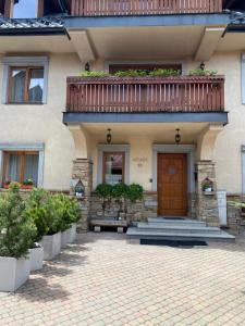 Casa con puerta de madera y balcón en Willa Arkady 2, en Zakopane