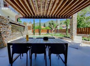a patio with a table and chairs and a pool at Lethe Villas with Private Pool Kato Gatzea Greece in Kato Gatzea