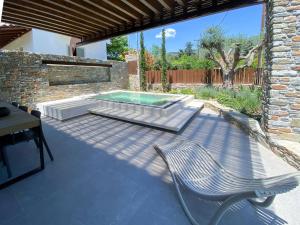 a patio with a chair and a swimming pool at Lethe Villas with Private Pool Kato Gatzea Greece in Kato Gatzea