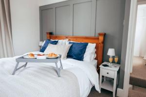 a bedroom with a bed with a tray of food on it at City Centre Secret in Kent