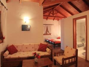 a living room with a couch and a bed at Archontiko Villas in Alykes