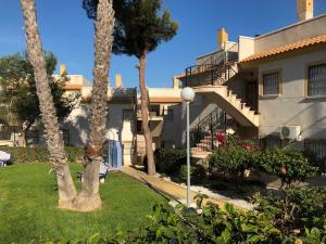 un edificio con palmeras frente a un patio en Saint James Park downstairs, en Orihuela