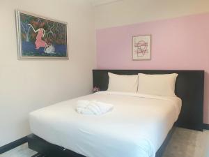 um quarto com uma grande cama branca num quarto em บันดารี่ ริชชี่ (Bhundaree Richy) em Hat Yai