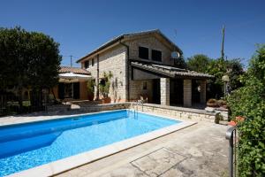 a swimming pool in front of a house at Karrua House in Modica