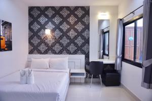 um quarto com uma cama, uma secretária e uma cadeira em บันดารี่ ริชชี่ (Bhundaree Richy) em Hat Yai