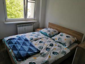 1 cama con 2 almohadas y ventana en Apartament Tygrysek en Ustka