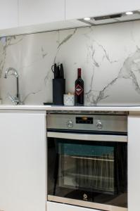 una cocina con fogones y una botella de vino en Hauzify I Apartamento Salamanca en Madrid
