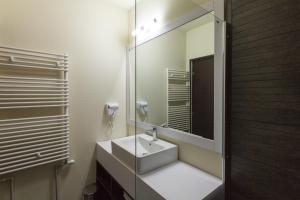 y baño con lavabo blanco y espejo. en YMY HOTELS Târgu Jiu, en Târgu Jiu