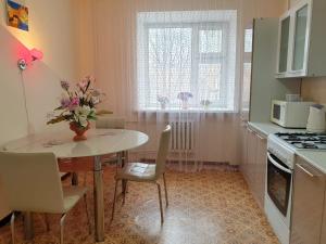 a kitchen with a table with a vase of flowers on it at Шикарная Двухкомнатная in Atyraū