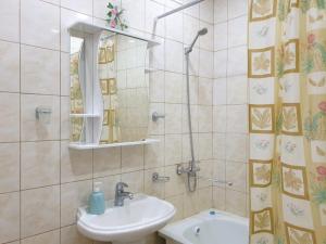 y baño con lavabo y ducha con espejo. en Шикарная Двухкомнатная, en Atyraū