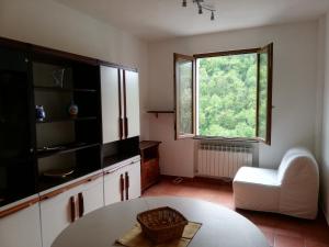 a kitchen with a table and a chair and a window at Casa Rosaguta in Vescina