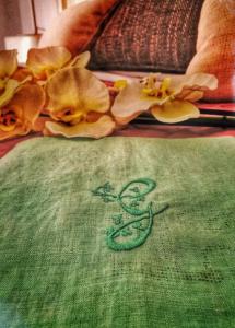 un paño verde con un símbolo en una cama en B&B Gianninella, en Agropoli