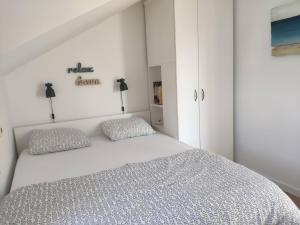 1 dormitorio con 1 cama blanca y 2 almohadas en House-Apartment More en Tribunj