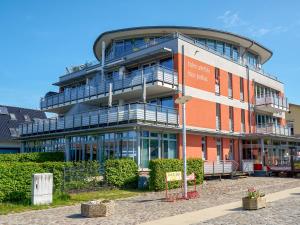 un immeuble de bureaux avec un panneau devant lui dans l'établissement Haus Putbus - Ferienwohnung 7 "Southwest beach", à Altefähr