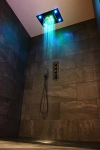 La salle de bains est pourvue d'une douche avec des lumières bleues. dans l'établissement Spa privatif by XELA, à Auxerre