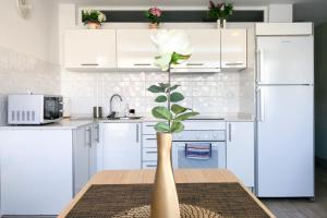 a white kitchen with a white flower in a vase on a table at Modern Apt with Pool - Yumbo & Beach in Maspalomas