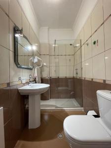 a bathroom with a toilet and a sink and a shower at Hotel Benilva in Durrës