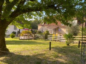 uma árvore com um parque infantil num quintal em Le Clos Romantic & Spa - Périgueux - Bassillac et Auberoche em Eyliac