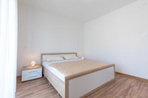 sypialnia z łóżkiem i drewnianą podłogą w obiekcie Apartments Lucija w Dubrowniku