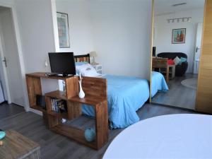 1 dormitorio con cama y espejo en Escale marine à Calais 4 étoiles en Calais