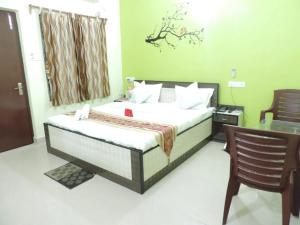 a bedroom with a bed with a table and a chair at Beach Facing Resort Mandarmani in Mandarmoni
