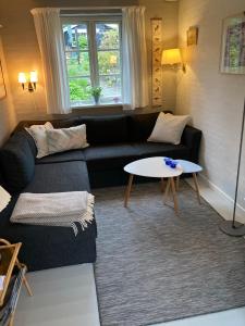 uma sala de estar com um sofá e uma mesa em Baghuset em Ebeltoft