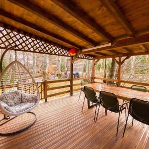 - une terrasse couverte avec une balançoire, une table et des chaises dans l'établissement De La Villa Brezovice, à Brezovicë