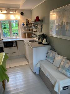 uma pequena cozinha com um lavatório e um sofá em Baghuset em Ebeltoft