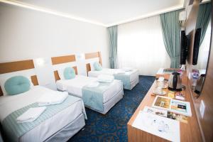 una camera d'albergo con due letti e una televisione di Afyon Orucoglu Thermal Resort a Afyon