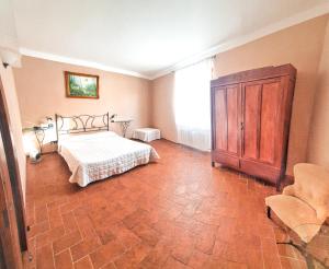 ランポレッキオにあるBellavista Hotel & Osteriaのベッドルーム1室(ベッド1台付)、木製キャビネットが備わります。