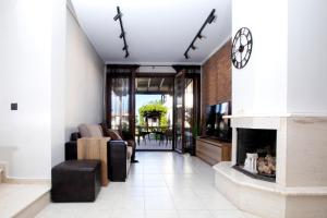 salon z kominkiem i zegarem na ścianie w obiekcie Porto Thea Alexandra Shared Pool Villa, Afytos w Áfitos