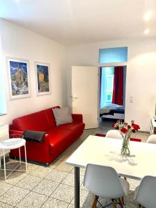 a living room with a red couch and a table at Chez Coco Apartment 1 Aachen in Aachen