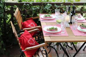 einen Holztisch mit roten Kissen und Teller mit Lebensmitteln in der Unterkunft Ferienhaus Ratteyer Idyll in Schönbeck
