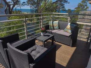 a balcony with two chairs and a table with a view of the ocean at Porta Mare Apartments LuxView II in Dziwnówek