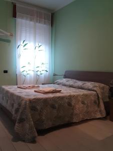 Cama en habitación con ventana y cortinas en Casa Silvia, en Padenghe sul Garda