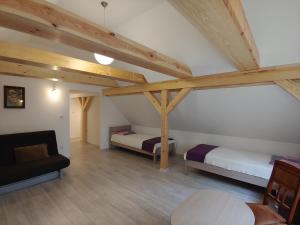 a attic room with two beds and a couch at Mazurska Perła in Jaśkowo