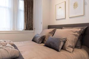 1 cama con almohadas en el dormitorio en Canal Dream Apartment, en Ámsterdam